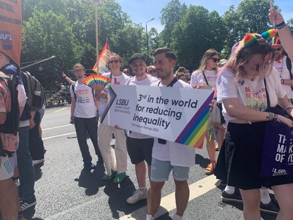 People carrying a banner saying 'LSBU 3rd in the world for reducing inequality'.